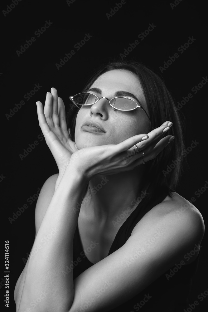 Black and white portrait of fashionable young woman on dark background Black and white portrait of fashionable young woman on dark background