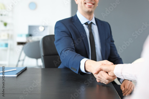 Human resources manager shaking hands with applicant after successful interview