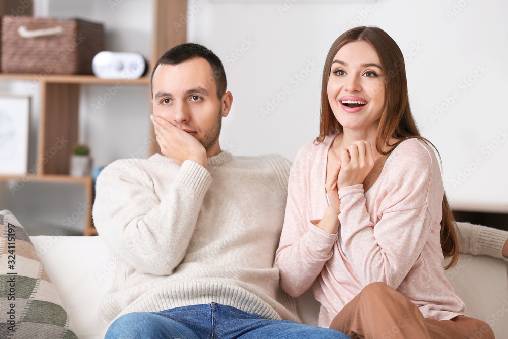 Beautiful young couple watching TV at home Beautiful young couple watching TV at home