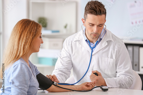 Male cardiologist examining...