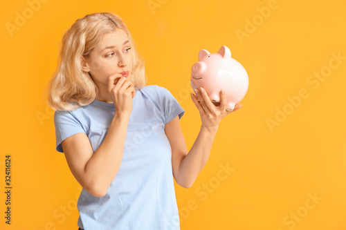 Young woman with piggy bank...