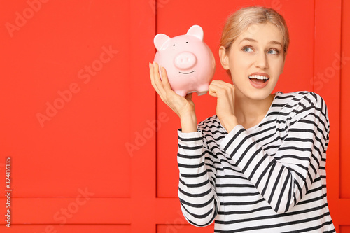 Young woman with piggy bank...