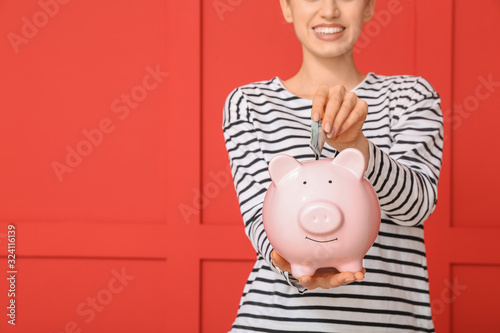 Young woman with piggy bank...