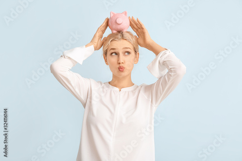 Young woman with piggy bank...