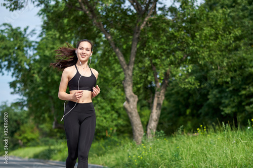 Young fitness asian woman running at forest trail. © Joe-L