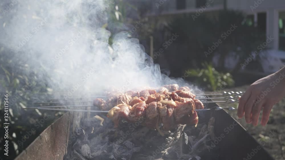 Grilling raw meat on outdoor grill with smoke. Grilling raw meat on outdoor grill with smoke.