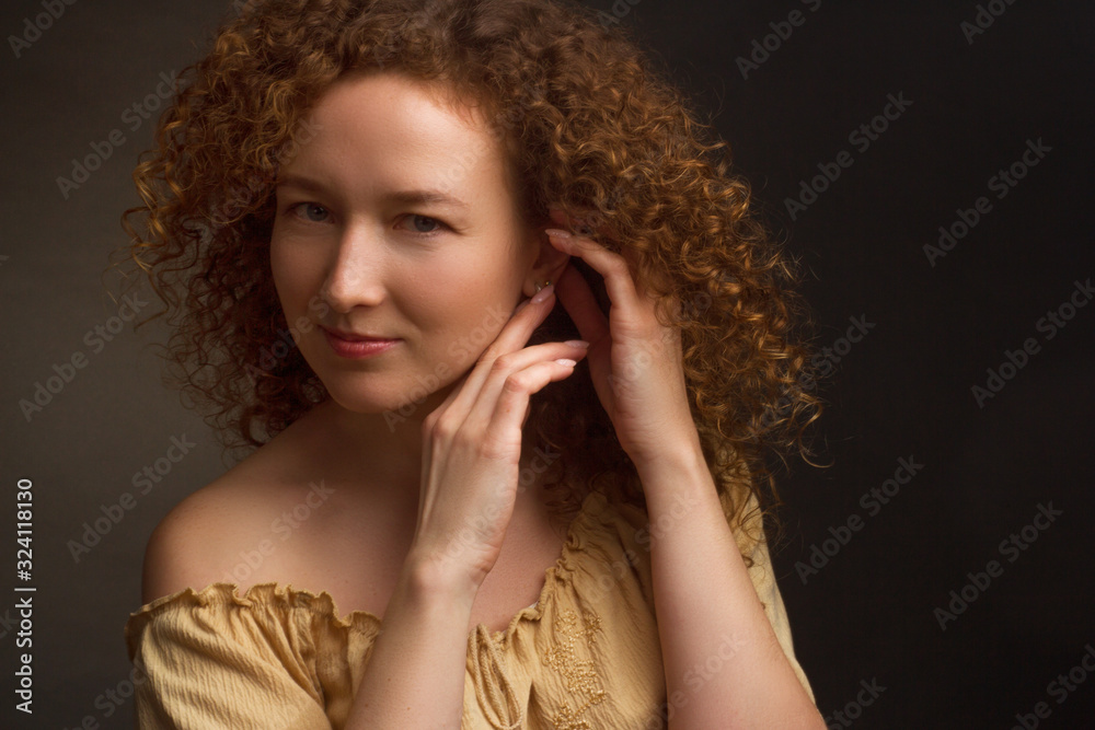 Studio portrait of a woman with brown curly hair Studio portrait of a woman with brown curly hair