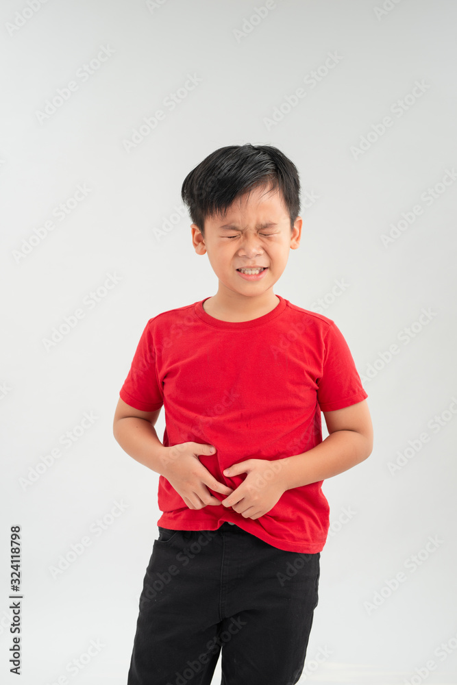 Sad little Asian boy suffering from stomach ache, holding his stomach, isolated on white background. Sad little Asian boy suffering from stomach ache, holding his stomach, isolated on white background.