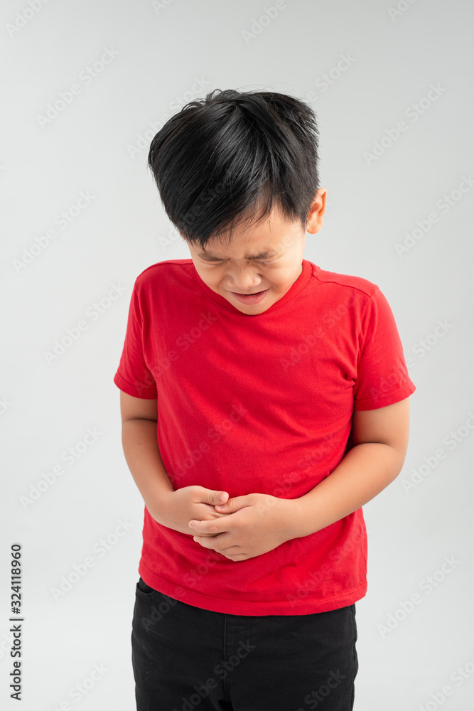Young little boy with hand on stomach because indigestion, painful illness feeling unwell. Ache concept. Young little boy with hand on stomach because indigestion, painful illness feeling unwell. Ache concept.