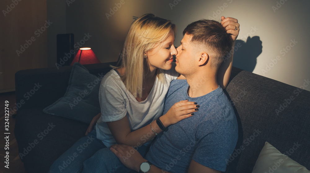 A lovely couple embracing each other sitting on bed are charmed by the sun that made their heart to melt A lovely couple embracing each other sitting on bed are charmed by the sun that made their heart to melt