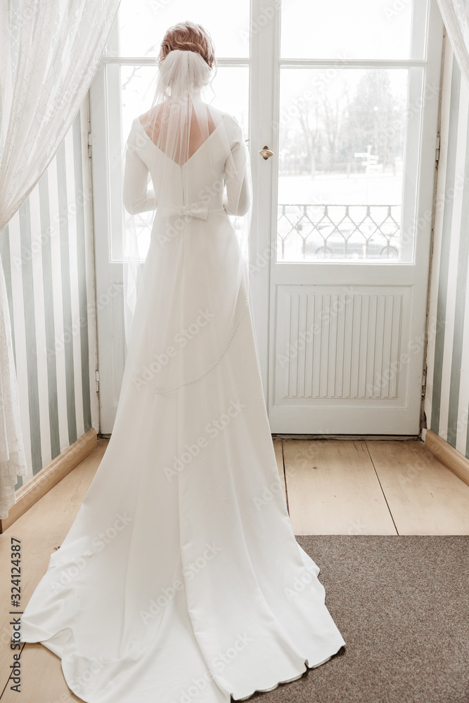 City Cesis, Latvia. Woman with wedding dress and white door. City Cesis, Latvia. Woman with wedding dress and white door.