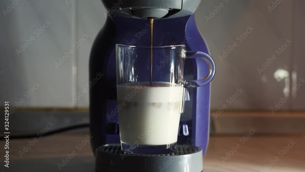 Making capuccino on a coffe mashine. Shot in real time and slow motion. Set on a kitchen counter with studio lighting.