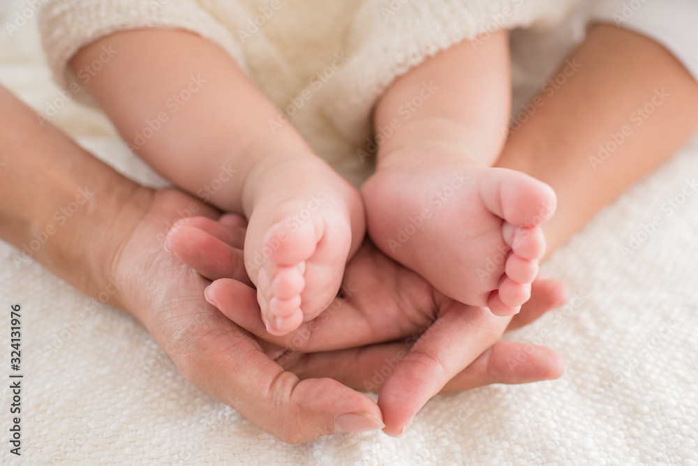 closeup newborn baby feet while the mother is carrying in home. baby feet in mother hands. mom and her Child. happy family concept. beautiful conceptual image of maternity. closeup newborn baby feet while the mother is carrying in home. baby feet in mother hands. mom and her Child. happy family concept. beautiful conceptual image of maternity.