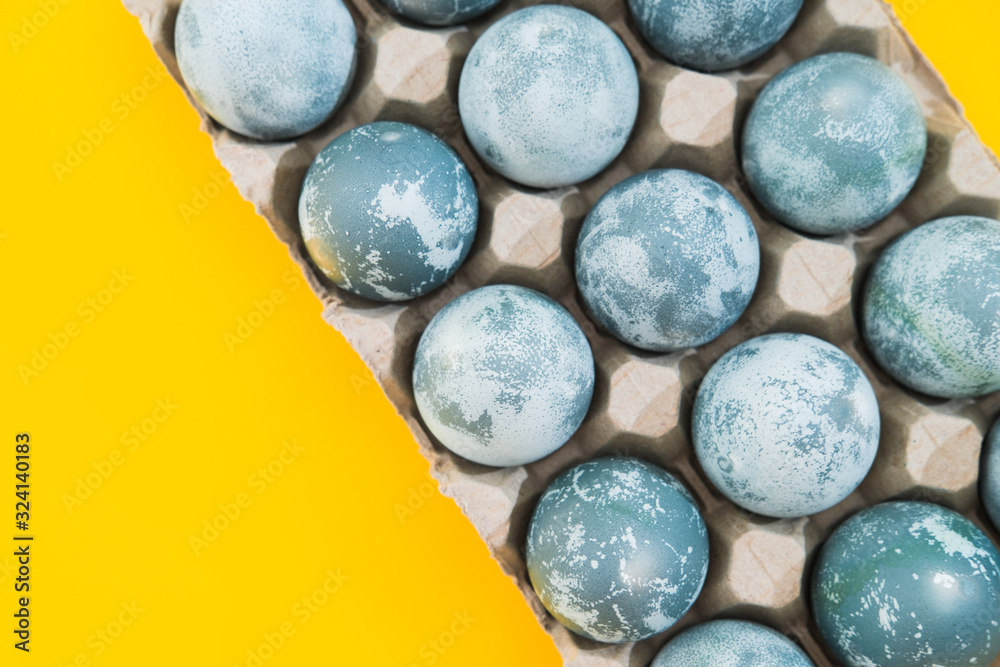 Blue textured colored Easter eggs on a bright yellow holiday background backdrop. Spring holiday concept. Copyspace. Flat lay. Top view.