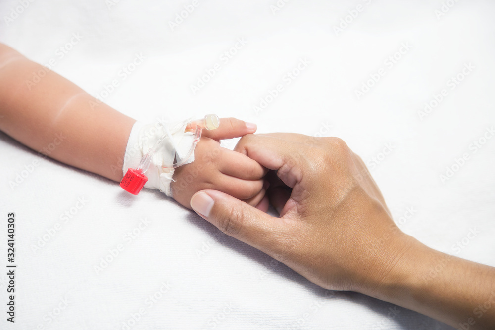 Mother holding baby hand give saline solution in bed fever patients in hospital. Mother holding baby hand give saline solution in bed fever patients in hospital.