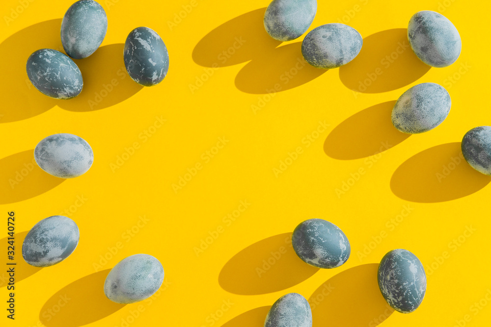 Blue textured colored Easter eggs on a bright yellow holiday background backdrop. Spring holiday concept. Copyspace. Flat lay. Top view. Blue textured colored Easter eggs on a bright yellow holiday background backdrop. Spring holiday concept. Copyspace. Flat lay. Top view.