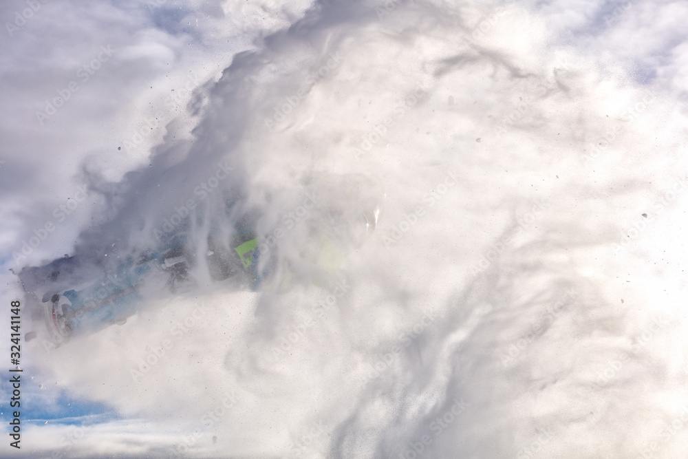 Obraz premium a Pro snowmobiler makes a jump with a big blast of snow and epic falls. bright snowmobile and suit. snowmobilers sports riding.