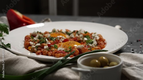 Full English Breakfast served in a pan. Fried eggs, beked beans, tomatoes, champignons, crispy bacon, sausages and toast. Placed on stone background. Top view with copy space. photo