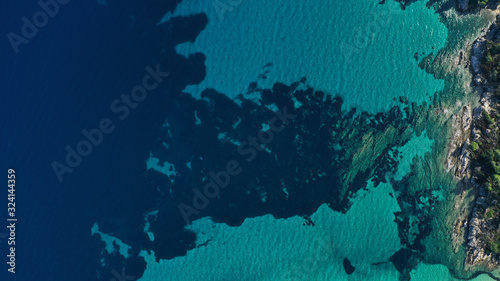 Aerial view of Halkidiki lagoon, Vouvourou beach, turquoise water of Aegean sea, rocks underwater. Greece seascape.