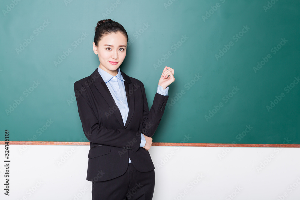 portrait of female teacher pointing to chalkboard. portrait of female teacher pointing to chalkboard.