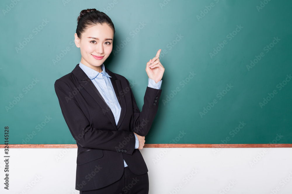 portrait of female teacher pointing to chalkboard. portrait of female teacher pointing to chalkboard.