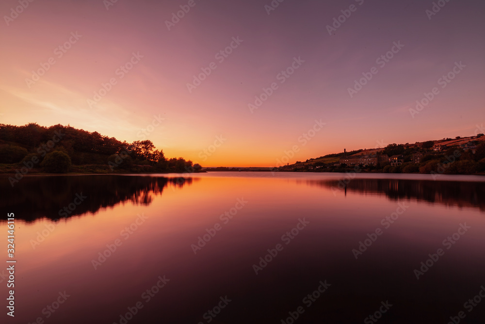 Colourful Sunset over water with reflection.