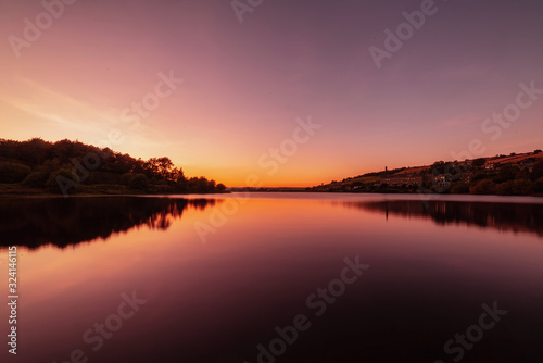 Colourful Sunset over water with reflection. © Tom