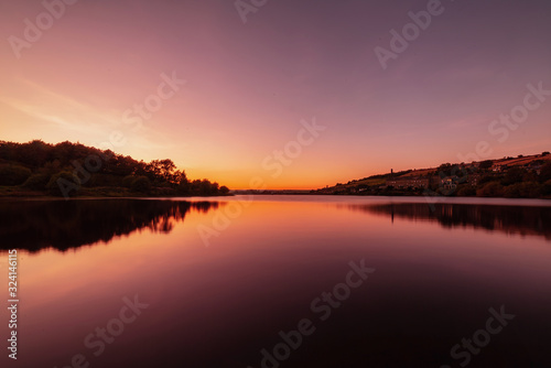 Colourful Sunset over water with reflection.