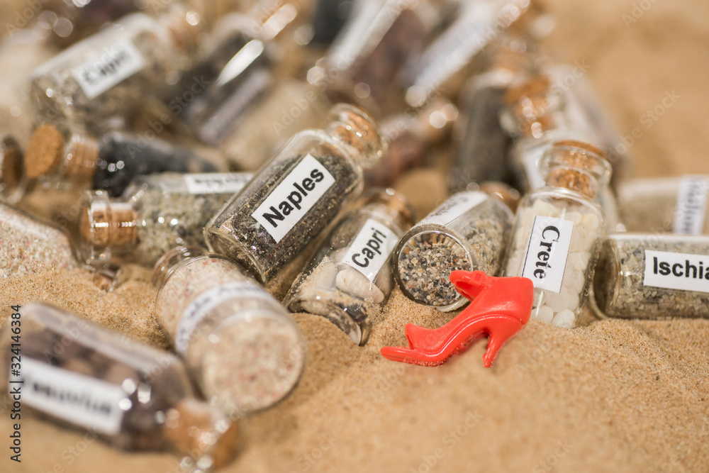 Glass test-tube with sand of different summer vacation destinations. Vacation time abstract photo. Glass test-tube with sand of different summer vacation destinations. Vacation time abstract photo.