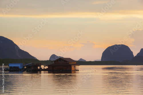 Beautiful sunset of fishing village in Phang Nga Bay with longtail wooden fishing boat ,Thailand