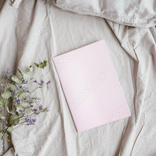Pink diary and flowers on the bed  flat  top view