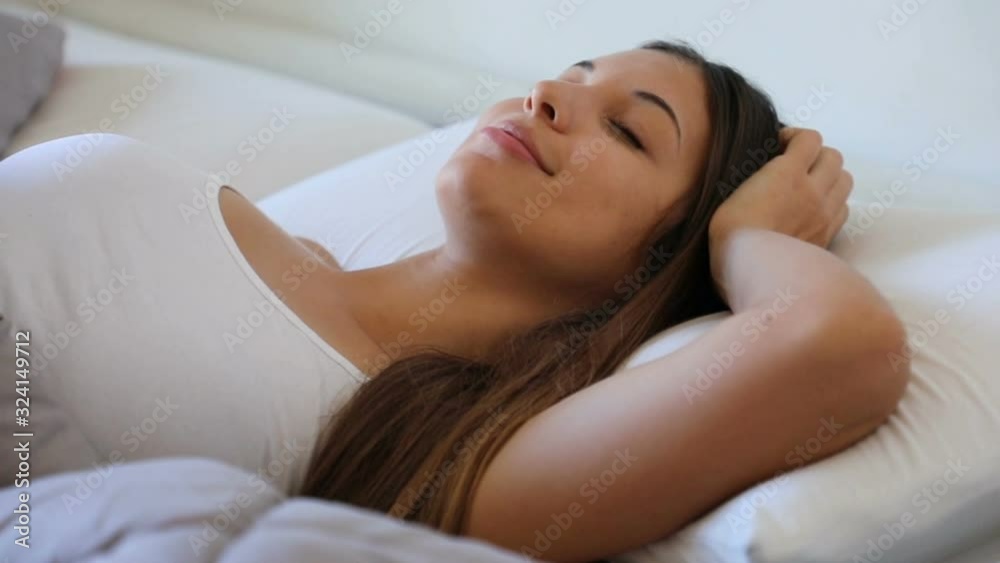 Sleeping young woman scratch her head satisfied in bed. Slow motion. Sleeping young woman scratch her head satisfied in bed. Slow motion.