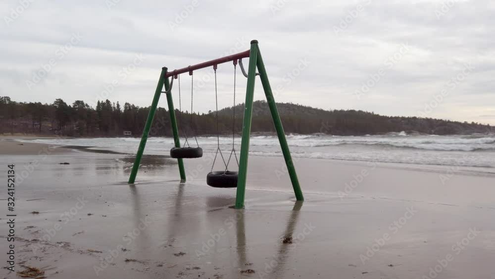 Swings moving slowly in the wind on a flooded beach Swings moving slowly in the wind on a flooded beach
