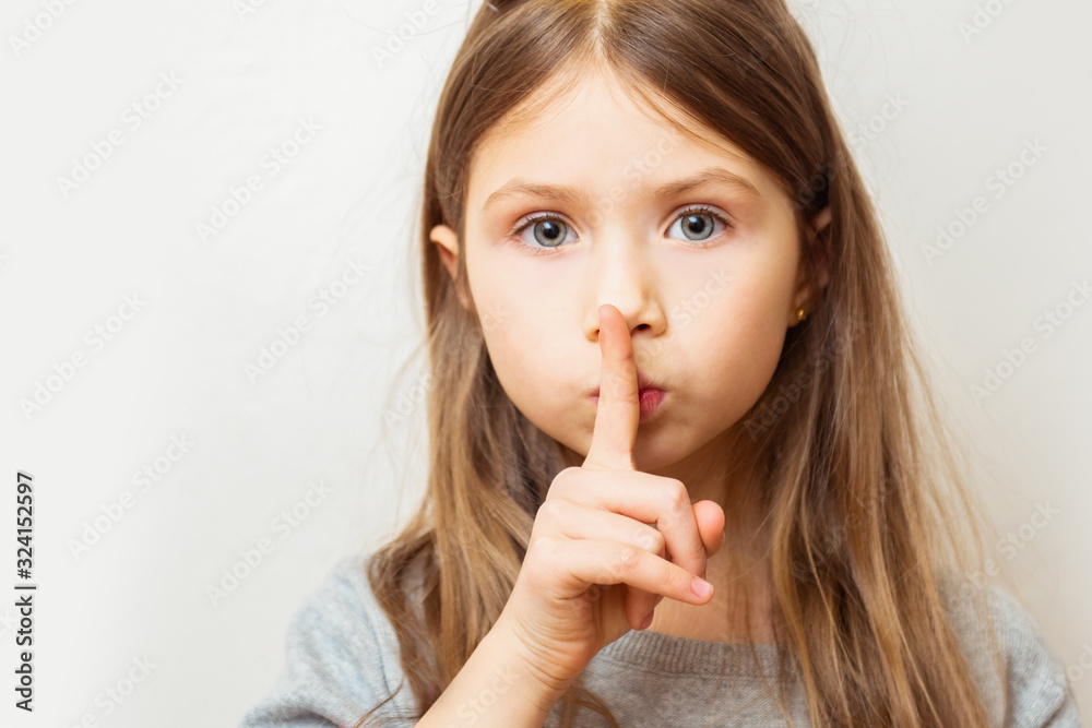 Portrait of beautiful child girl with finger on lips, isolated over white background Portrait of beautiful child girl with finger on lips, isolated over white background