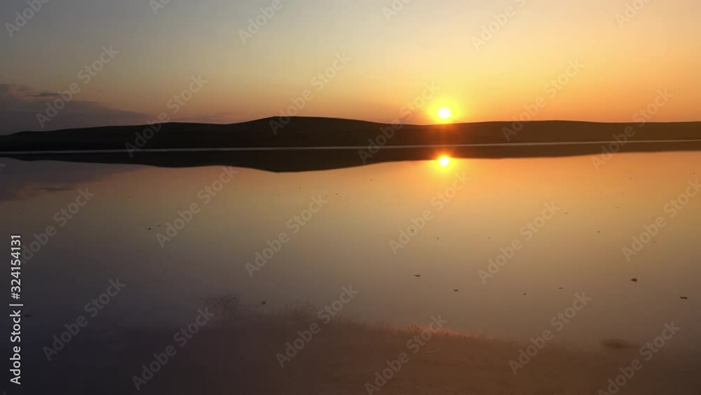 Beautiful pink mineral lake in Crimea, aerial view. Flight over the salty Koyashsky lake against the sunset in the evening. Shooting a small lake from above. No people. Beautiful pink mineral lake in Crimea, aerial view. Flight over the salty Koyashsky lake against the sunset in the evening. Shooting a small lake from above. No people.