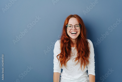 Fun loving happy young woman standing laughing