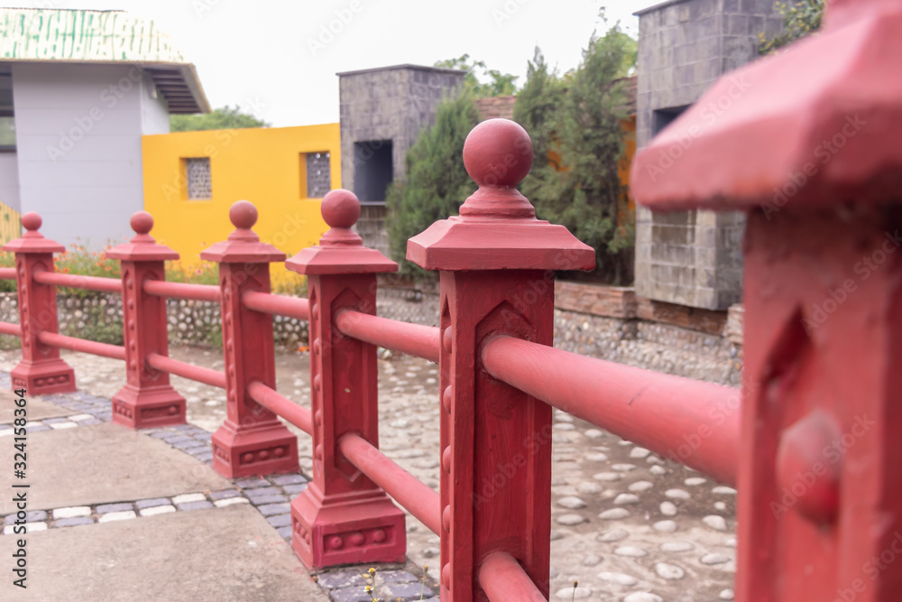 Beautiful red railings closeup in a Buddhist park. Spirituality and meditation concept