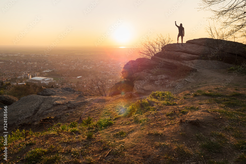 Man looking to sunset on mountain cliff