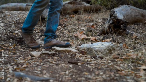 Wallpaper Mural Man's shoes boots on a hike walks down rocky trail through tall grass on leafy path in the woods. Torontodigital.ca
