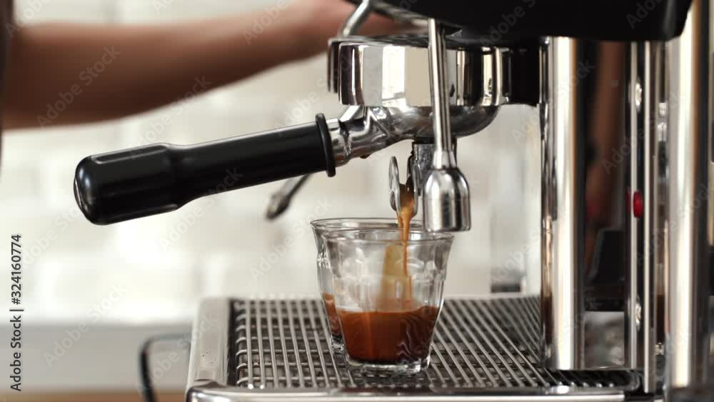 Coffee maker machine brewing double shot Espresso into tumbler glass cups in cafe Coffee maker machine brewing double shot Espresso into tumbler glass cups in cafe