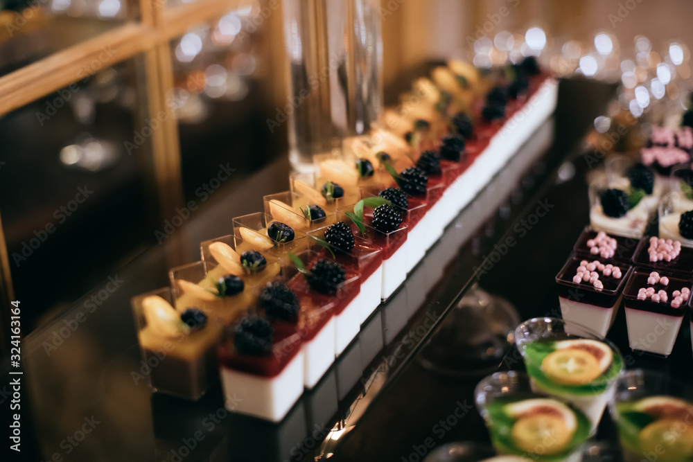 Delicious cakes with fresh berries on dessert table at wedding party Delicious cakes with fresh berries on dessert table at wedding party