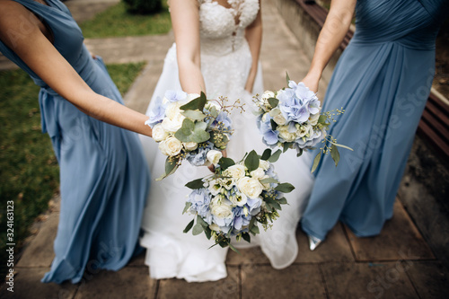 Lovely blue bouquets in the hands of the bride and her friends