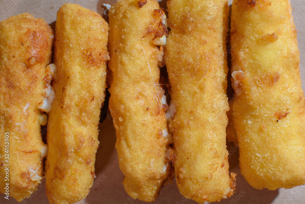Cheese sticks on a wooden tray. Close-up. Junk food. Cheese sticks on a wooden tray. Close-up. Junk food.