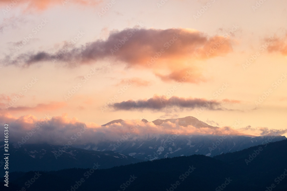 mountain peaks at sunset in the clouds