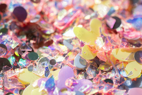 Easter spring background - pastel holographic confetti, glitter and flowers abstract texture