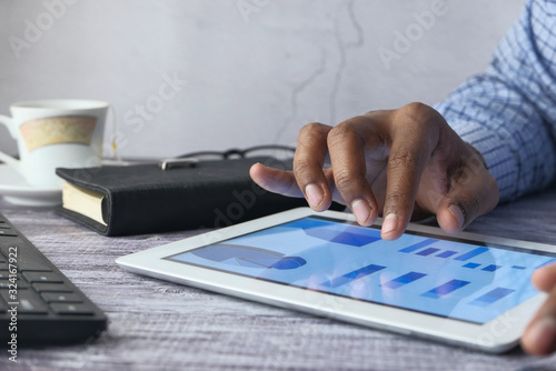 Close up of man hand analyzing chart on digital tablet 