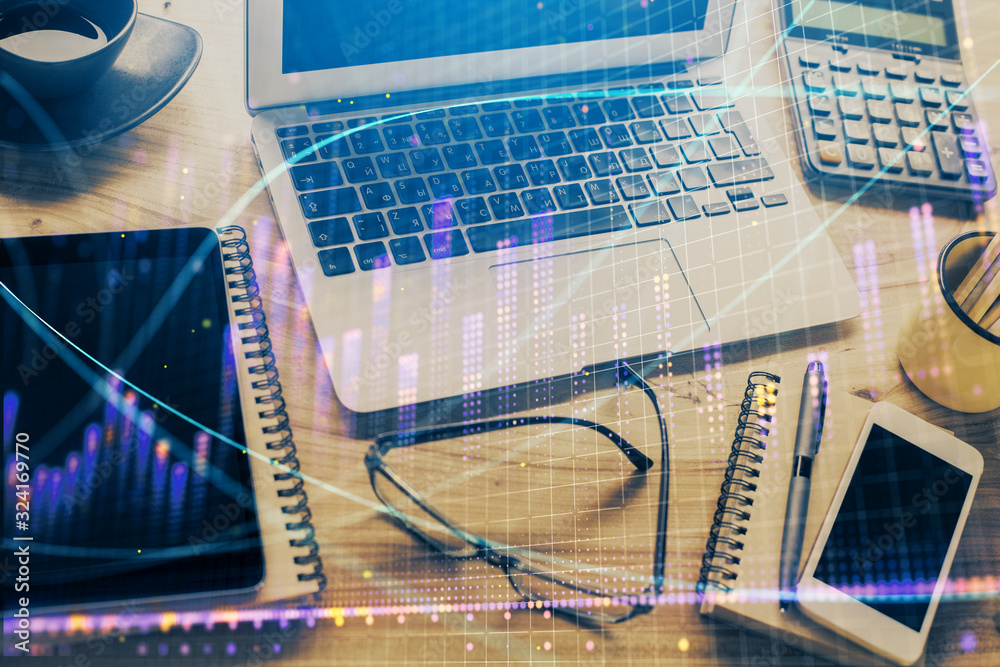 Financial graph colorful drawing and table with computer on background. Double exposure. Concept of international markets. Financial graph colorful drawing and table with computer on background. Double exposure. Concept of international markets.