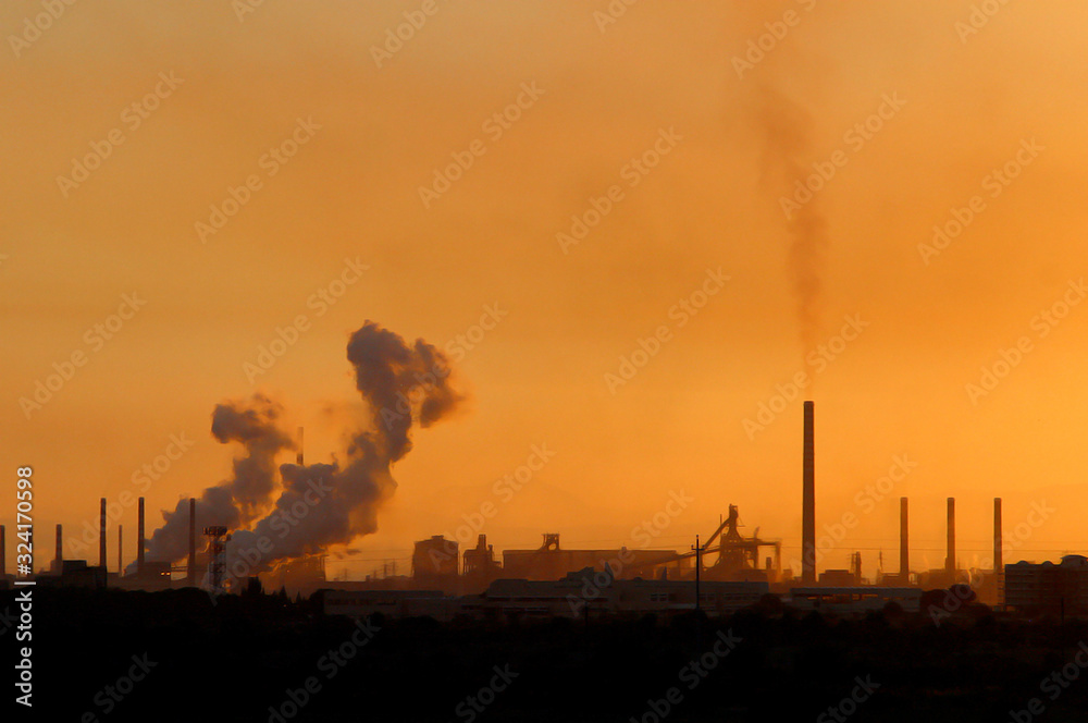 Smoke from industrial chimneys at sunset