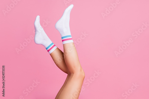 Cropped profile side view of nice attractive long vertical feminine legs wearing white casual soft socks season perfect fit size isolated over pink pastel color background photo
