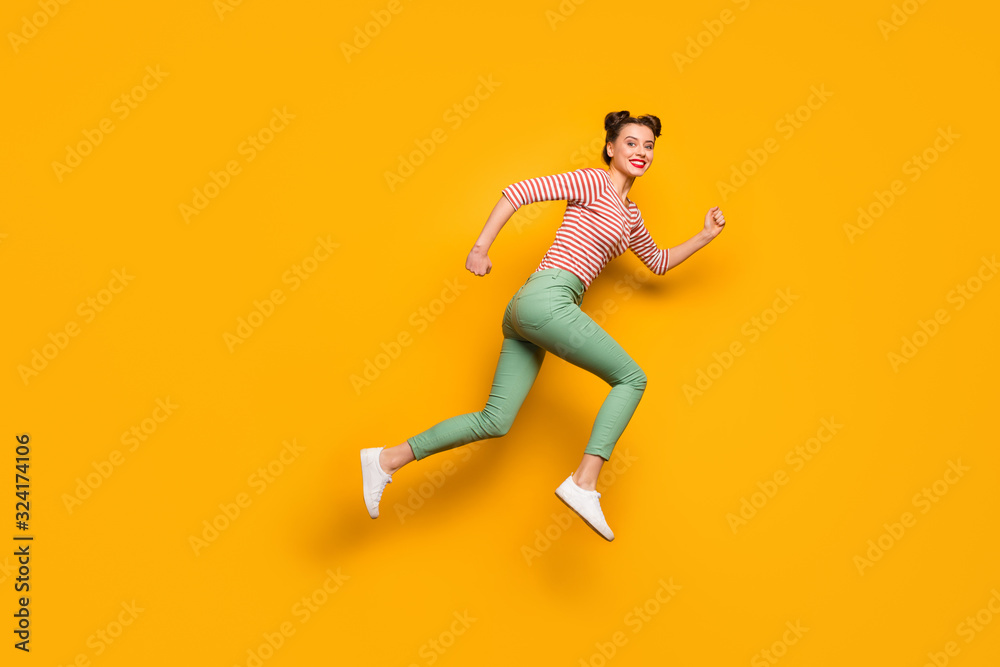 Full length photo of pretty lady jumping high rushing low prices sales shopping center wear red white pullover shirt green pants footwear isolated bright yellow background